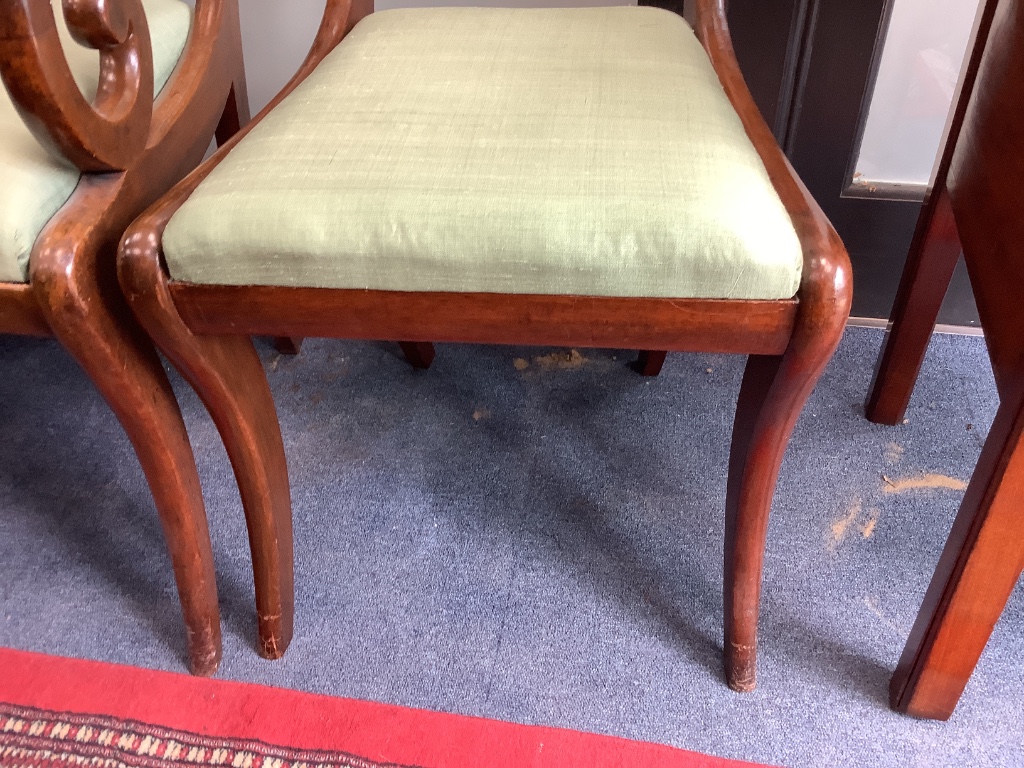 A set of six George V mahogany sabre leg dining chairs (two with arms)